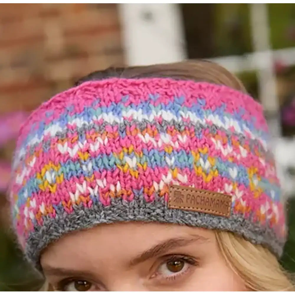 Multicolored knitted headband with a brand logo worn by a person.