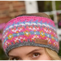 Multicolored knitted headband with a brand logo worn by a person.