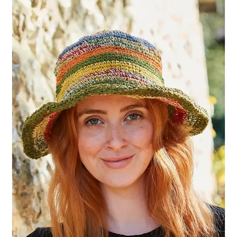 Model wearing a crochet striped hat. Hat is multi coloured.