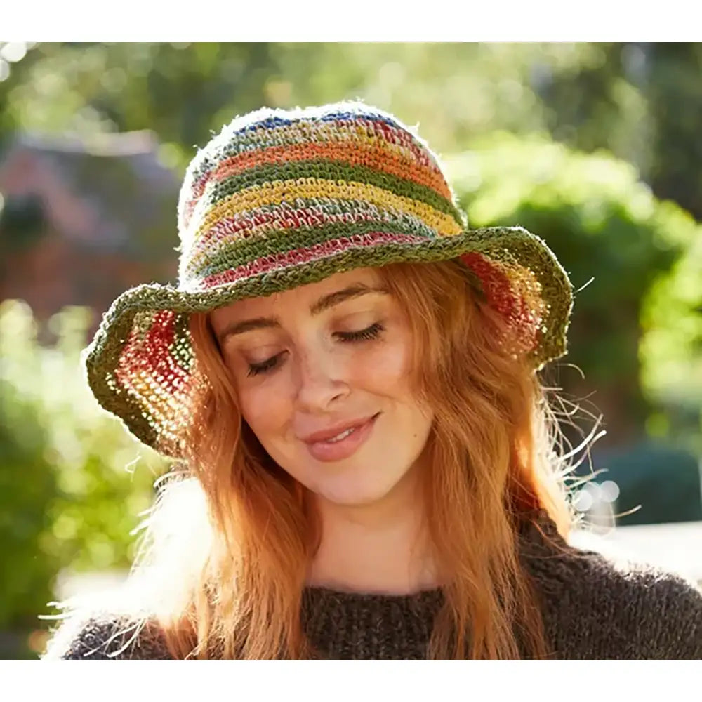 Model wearing a crochet striped hat. Hat is multi coloured.
