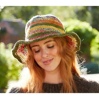 Model wearing a crochet striped hat. Hat is multi coloured.