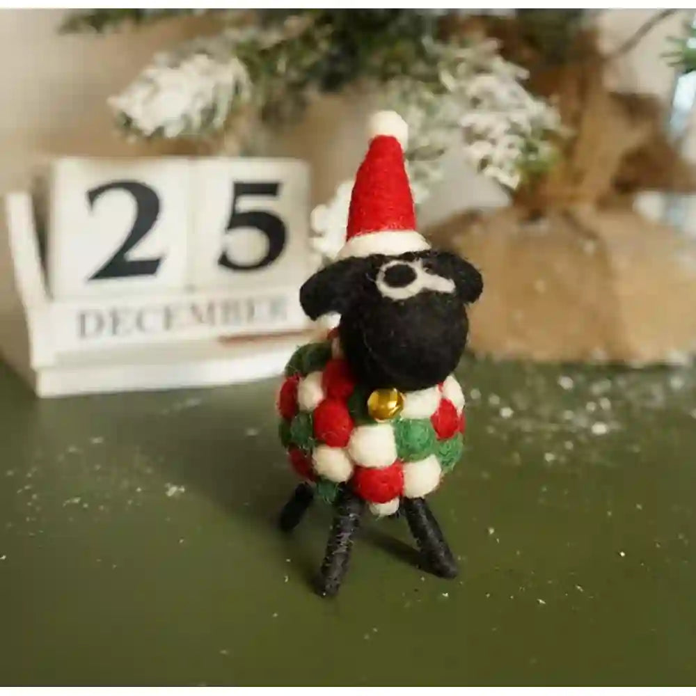 Felt sheep with a black face and a white, red and green ball body. Has a red santa hat on.