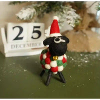 Felt sheep with a black face and a white, red and green ball body. Has a red santa hat on.