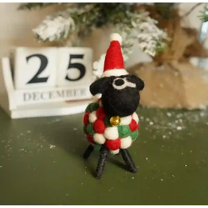 Felt sheep with a black face and a white, red and green ball body. Has a red santa hat on.
