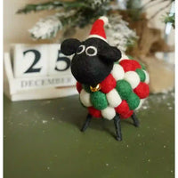Felt sheep with a black face and red santa hat on. Body made up of conjoined red, green and white balls.