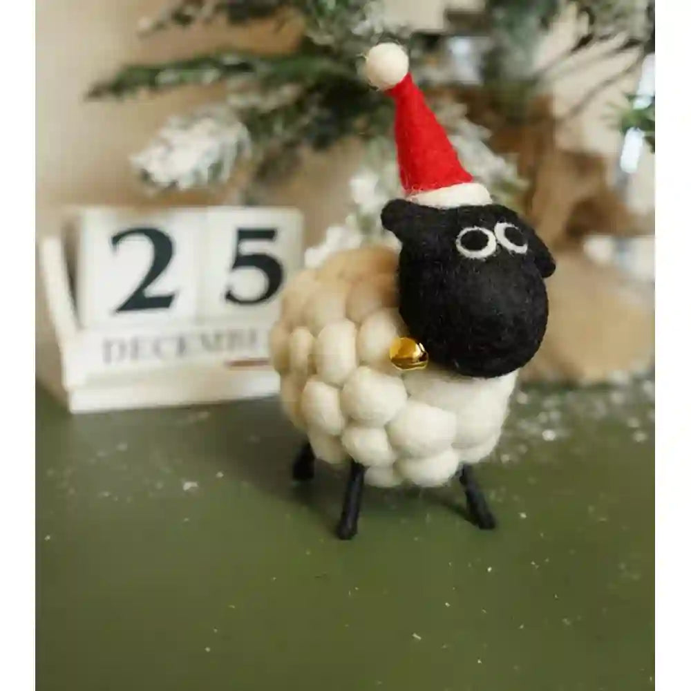 White sheep with a black face and red santa hat on.