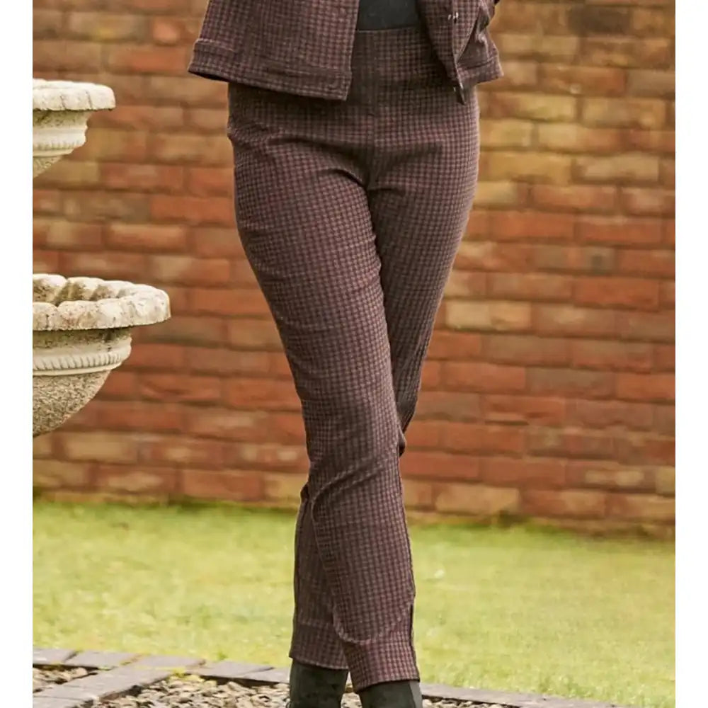 Person wearing a brown dogtooth print trousers with a black contrast. 