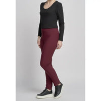 Person wearing a black top and maroon pants on a light gray background