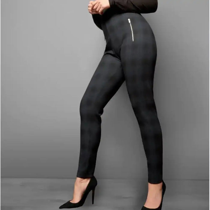 Black leggings worn by a person on a gray background