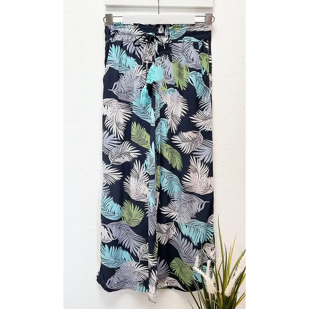 Tropical leaf patterned pants on a white background