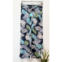 Tropical leaf patterned pants on a white background