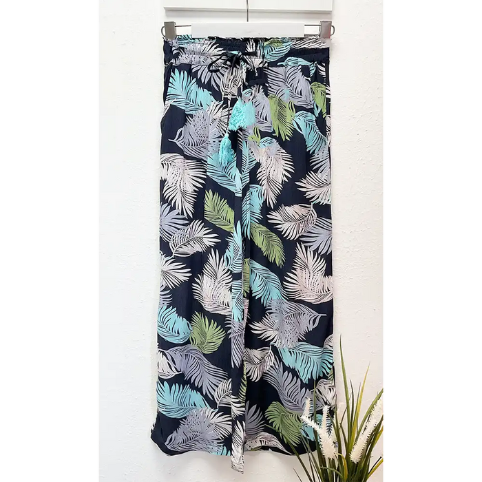 Tropical leaf patterned pants on a white background