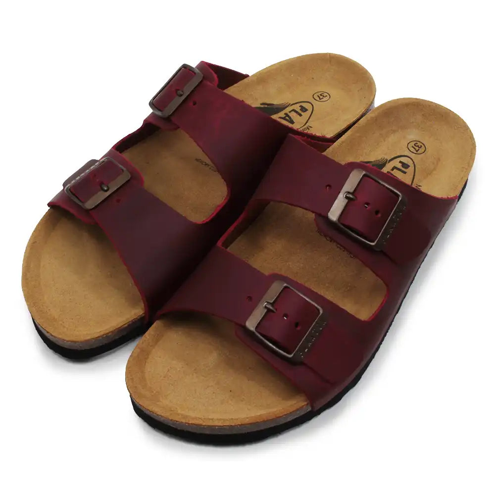 Pair of maroon sandals with brown soles on a white background