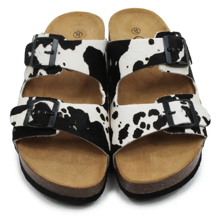 Pair of sandals with cow print pattern on a white background