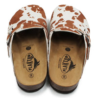 Pair of cow print sandals with visible brand logo on a white background