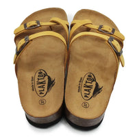 Mustard double buckled strappy sandals on a white background.