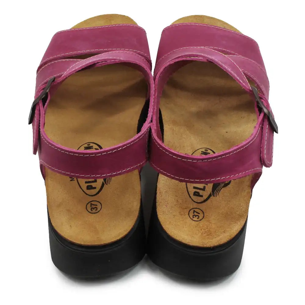 Pair of pink sandals with wooden soles on a white background