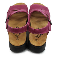 Pair of pink sandals with wooden soles on a white background