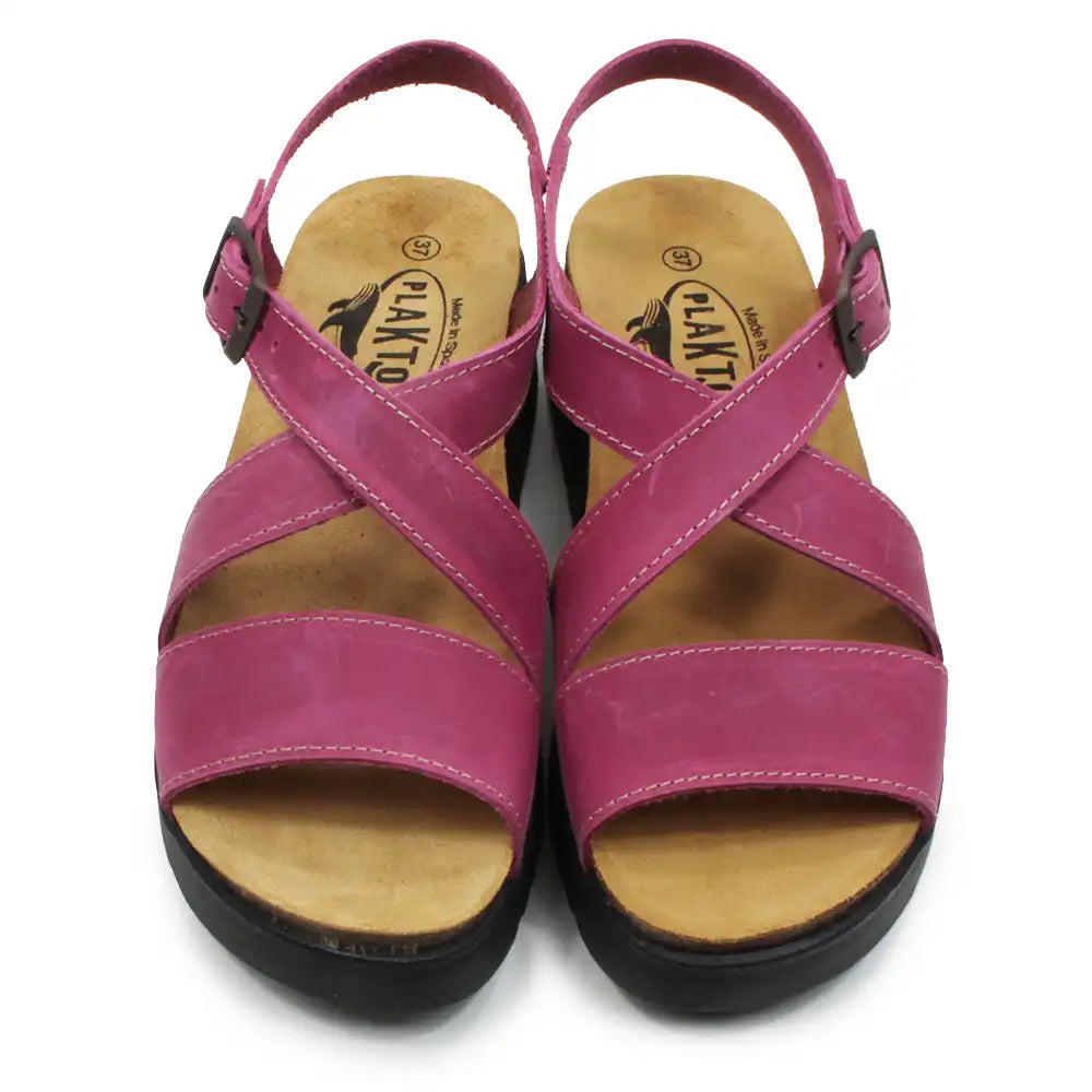 Pair of pink sandals with wooden soles on a white background