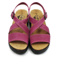 Pair of pink sandals with wooden soles on a white background