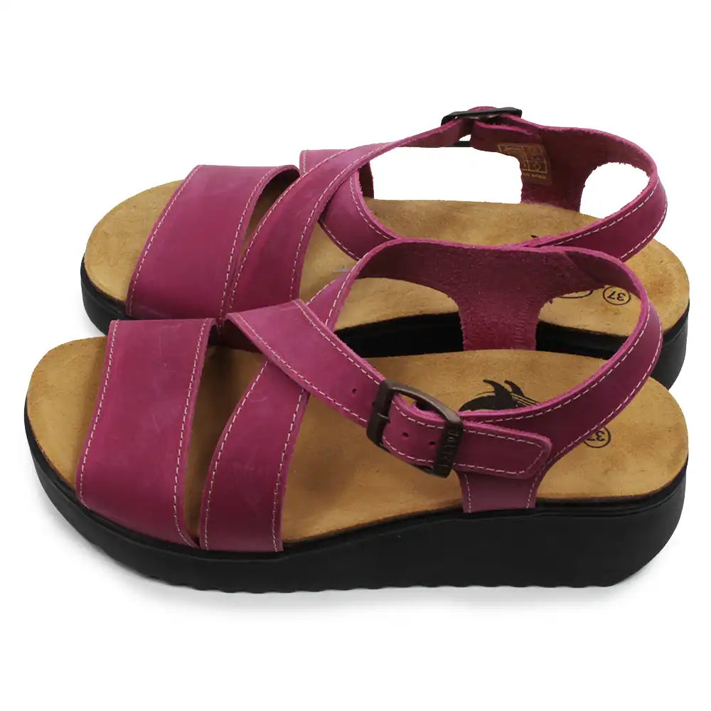 Pair of fuchsia sandals with brown soles on a white background