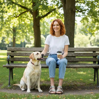 Woman sitting on a bench with a dog in a park