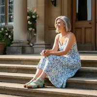 Woman in a floral dress sitting on steps outside a building