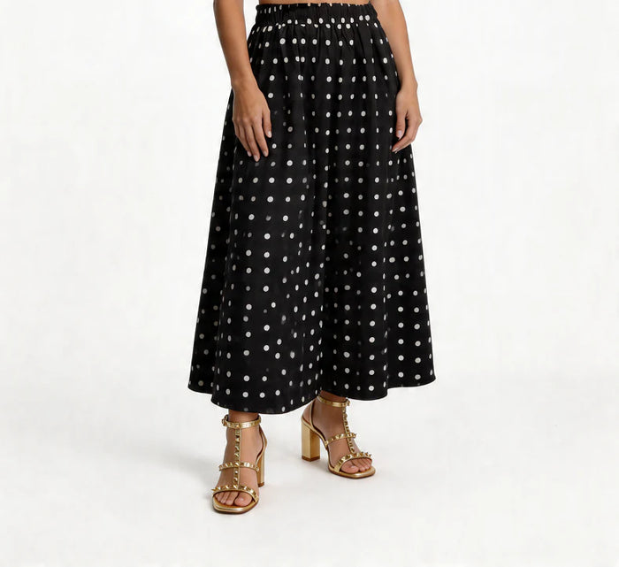 Black polka dot skirt worn by a person on a white background