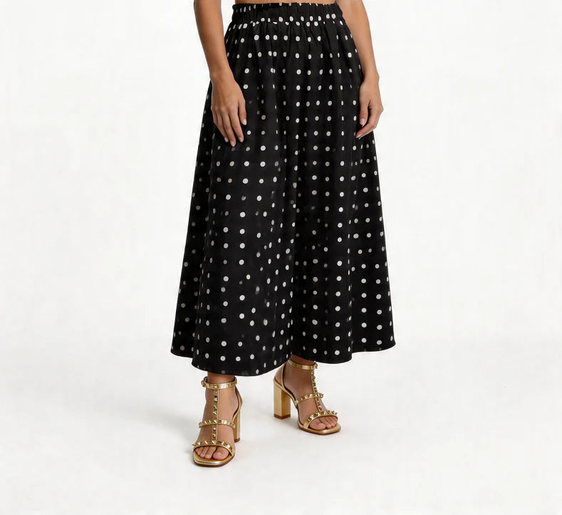 Black polka dot skirt worn by a person on a white background