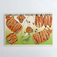A wooden pop-up and match puzzle for children featuring cartoon illustrations of a Highland cow in orange-brown striped patterns on a light green background.