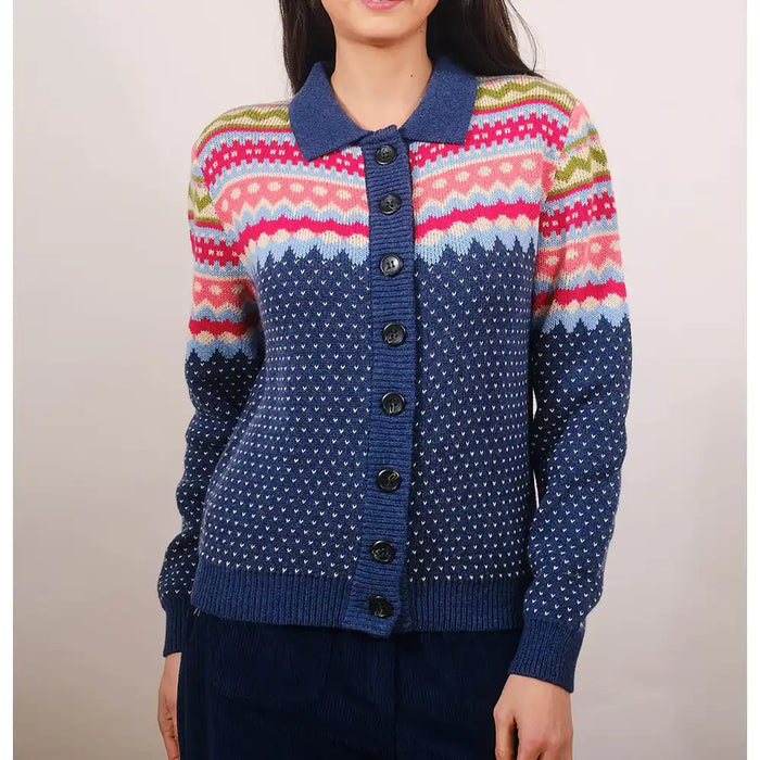 Person wearing a colorful patterned cardigan with a plain background