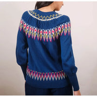 Blue sweater with colorful pattern on a plain background