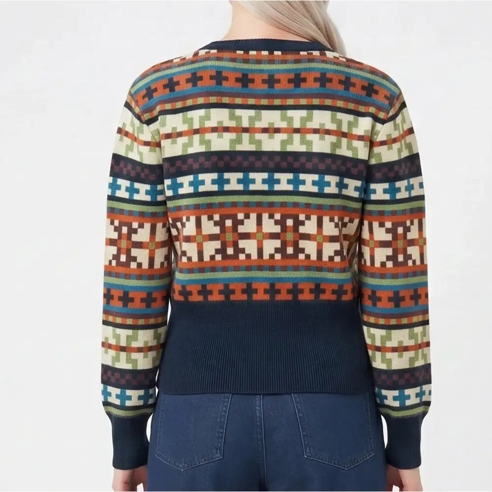 A person shown from the back wearing a long-sleeve knit sweater with a multicolor geometric Fair Isle pattern and a solid navy ribbed hem, cuffs, and collar, paired with blue jeans against a plain white background.