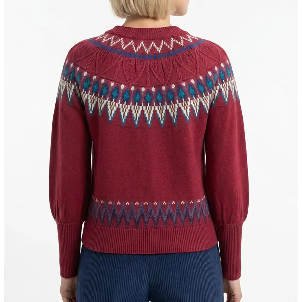 A woman shown from the back wearing a burgundy Fair Isle knit sweater with blue and cream geometric patterns across the shoulders and upper back, paired with dark blue corduroy pants against a plain white background.