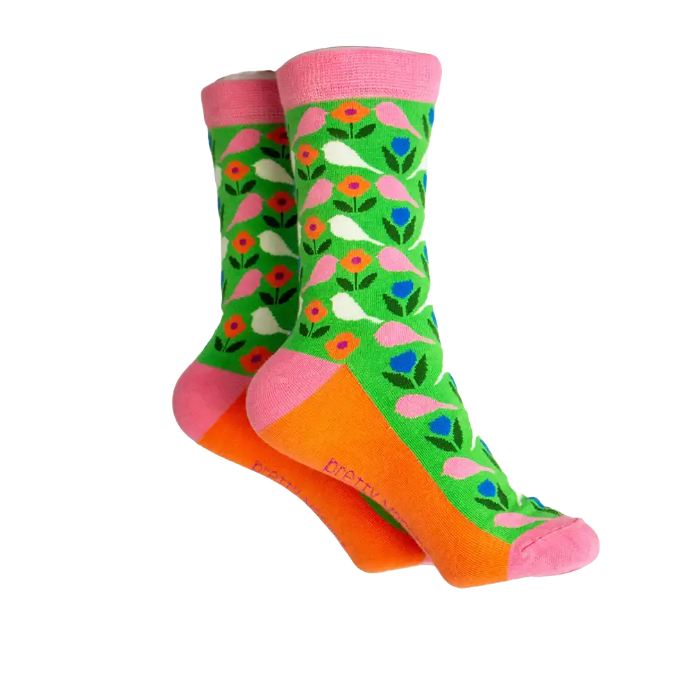 Green sock with white and pink budgies on it. Orange coloured sole with pink ankle hem, heel and toe.