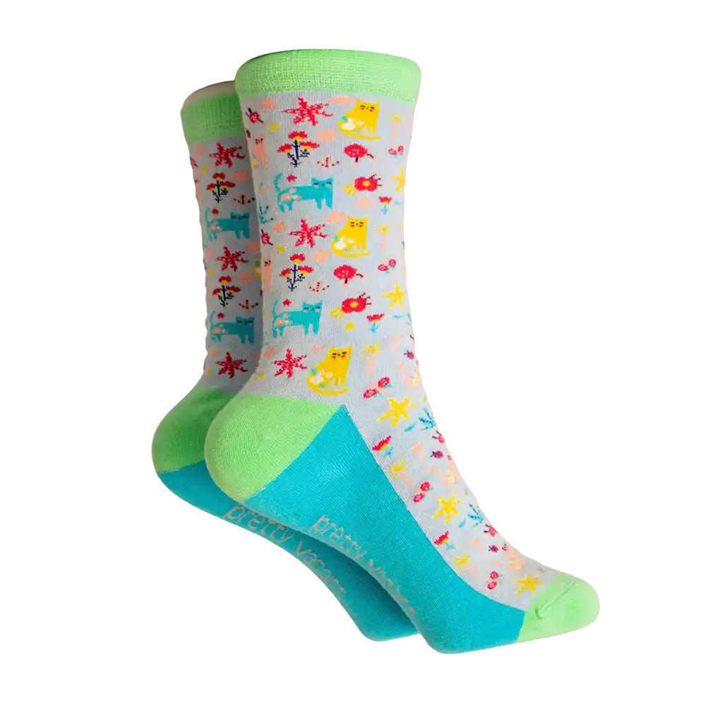 Grey based socks with a green ankle heel and toe. Bright blue sole. Covered with multi coloured cats and flowers