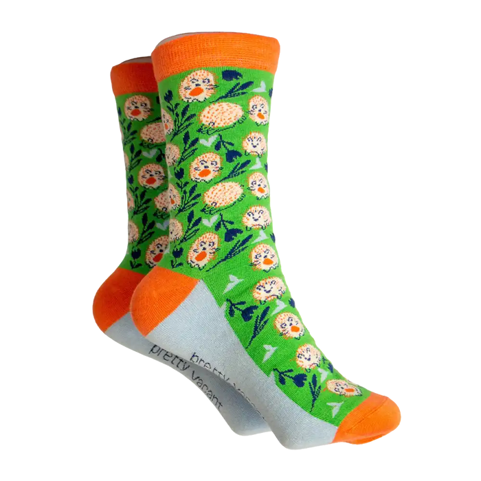 Green socks with orange and white hedge hogs on. Orange ankle, heel and toe. Grey sole.