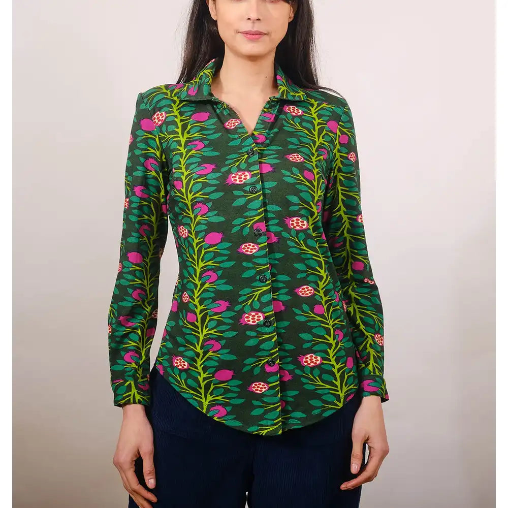 Woman wearing a green floral patterned shirt against a plain background