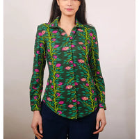 Woman wearing a green floral patterned shirt against a plain background