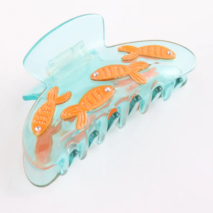 Pale blue claw clip with four orange fish with diamante eyes. 