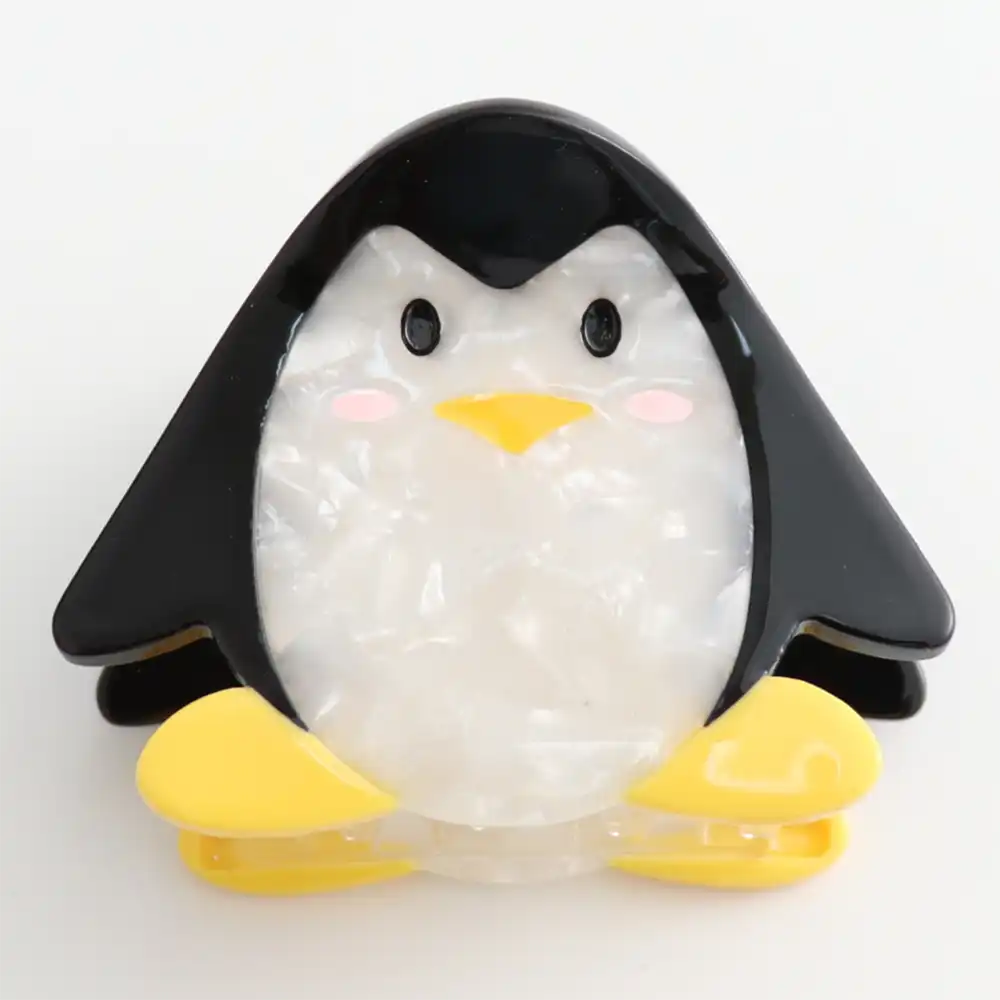 Picture of a penguin hair claw clip  in black and white with yellow feet. 