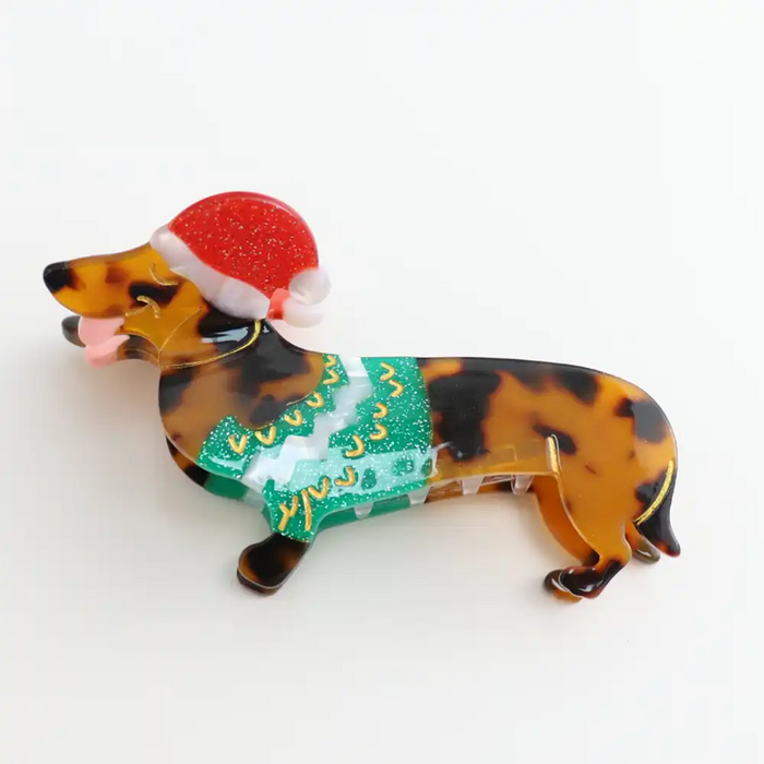 Picture of a dappled brown Christmas dachshund hair claw clip  who wears a Christms hat and a green waistcoat.