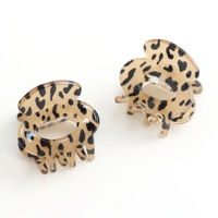 Picture of two mini hair claw clip  in animal print design plastic on a white background. 