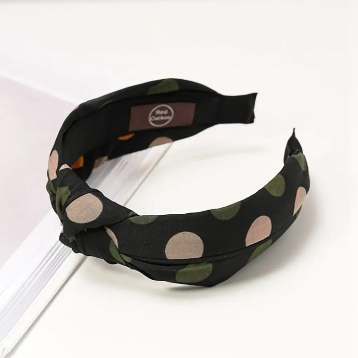 Navy based alice band with a grey and deep green spotty pattern. 