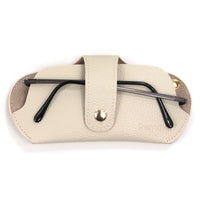 Beige glasses case with black glasses inside on a white background
