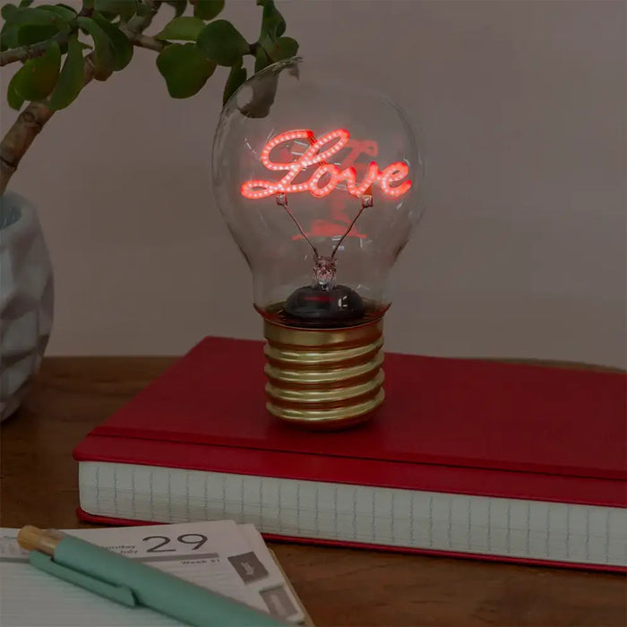 light bulb with word 'love' in pink in he middle.