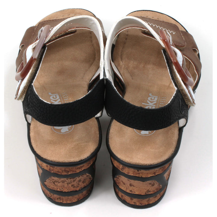 Rieker cork wedge sandals. Velcro fitting and adjustment. Brown over toes strap. White over upper foot strap with brown buckle detail. Black strap around the ankle. Tan insoles. Back view.