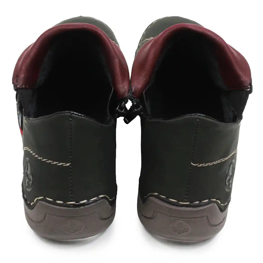 A pair of green faux leather slip-on shoes with burgundy inner lining and white contrast stitching, shown from the back on a white background.