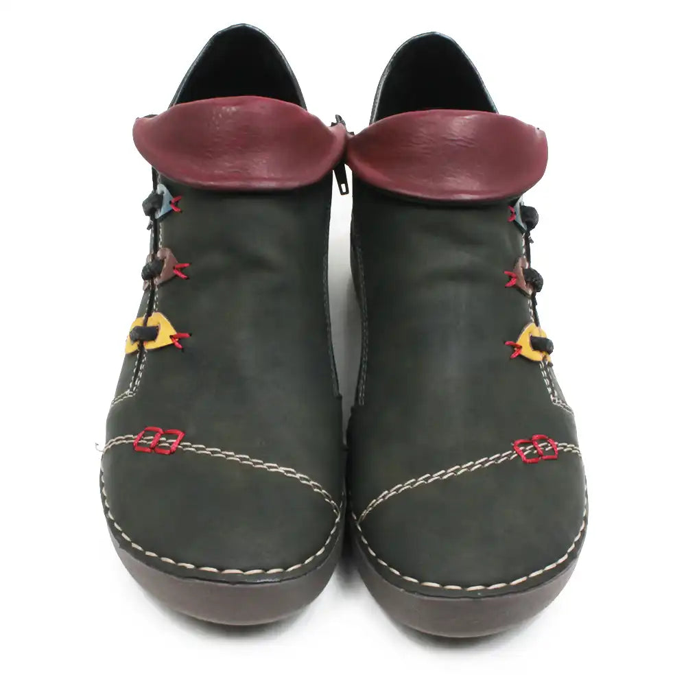A pair of dark olive green faux leather ankle boots with burgundy faux leather collar tabs, decorative red and yellow laces, and white contrast stitching on a white background.