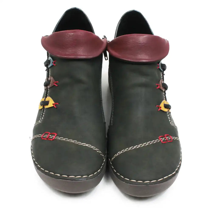 A pair of dark olive green faux leather ankle boots with burgundy faux leather collar tabs, decorative red and yellow laces, and white contrast stitching on a white background.